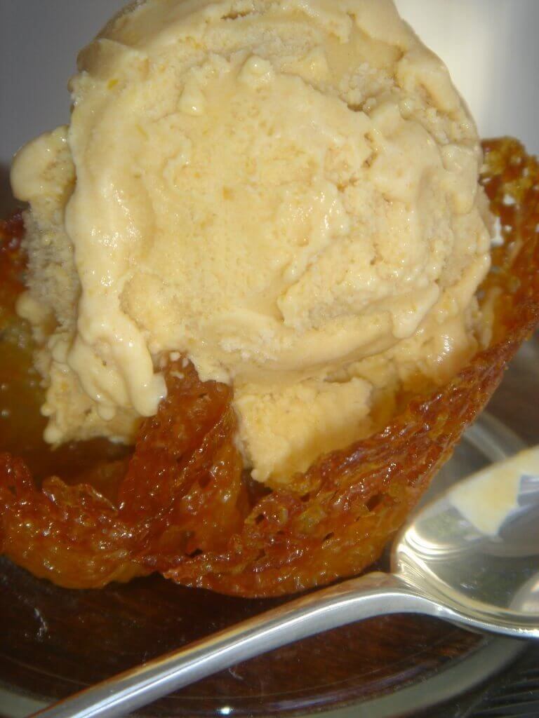 A bowl of pumpkin ice cream in an almond cookie cup.
