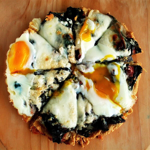 The toppings on this Swiss chard tart include sautéed chard with garlic, grated cheese, and a couple of eggs — a combination I really adore, in a buttery, cornmeal tart shell. It NEVER fails to please. // alexandracooks.com The toppings on this Swiss chard tart include sautéed chard with garlic, grated cheese, and a couple of eggs — a combination I really adore, in a buttery, cornmeal tart shell. It NEVER fails to please. // alexandracooks.com