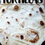 A homemade flour tortilla on a board.