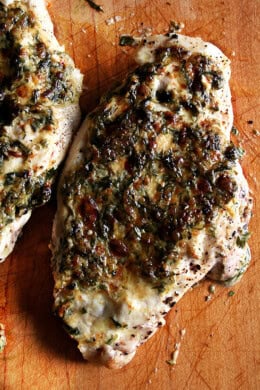 Broiled tarragon chicken breasts on a board.