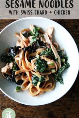 A bowl of sesame noodles with swiss chard.
