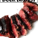 Pan-seared and sauced wild duck breast on a plate.