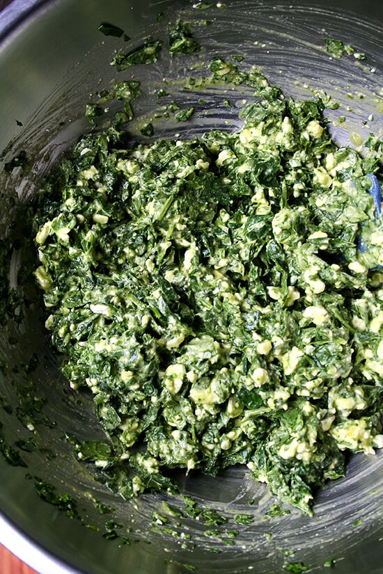 A large bowl filled with spanakopita filling.