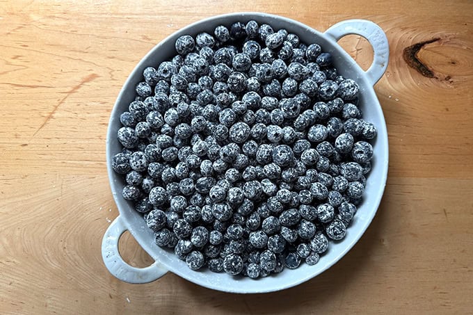 A gratin dish filled with blueberries coated in cornstarch.