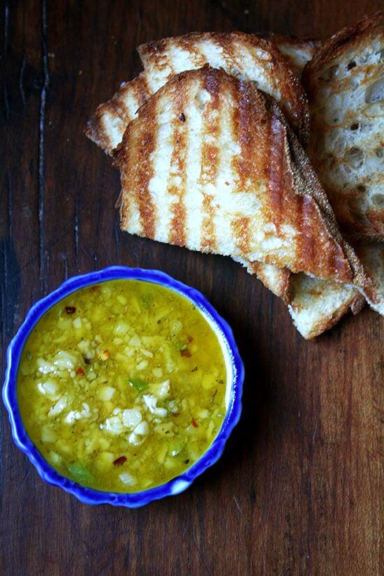 A bowl of Salsa di Parmigiano aside grilled bread.