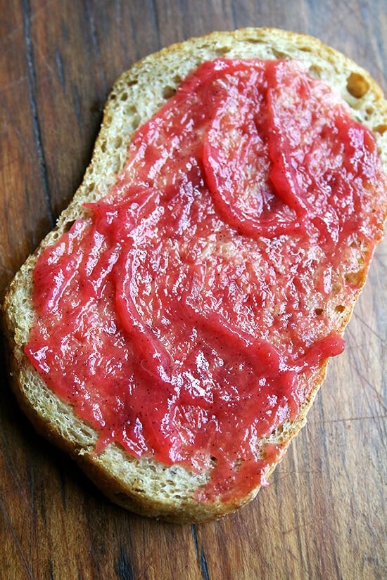 A slice of homemade peasant bread spread with homemade rhubarb jam.