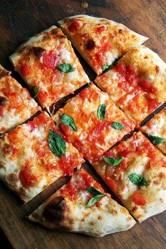 A margherita pizza cut into pieces. 