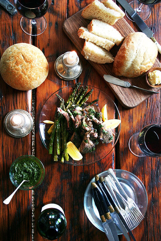 Bright green and fresh, these broiled lamb chops with mint sauce bear no resemblance to mint jelly and taste more like a salsa verde or a nut- and cheese-free pesto. It complements the lamb so well, but it's the kind of sauce you'll end up drizzling all over your plate, dragging your spears of roasted asparagus through, and mopping up with your bread throughout your meal. // alexandracooks.com An overhead shot of a dinner with homemade bread, mint sauce, broiled lamb chops, and red wine.