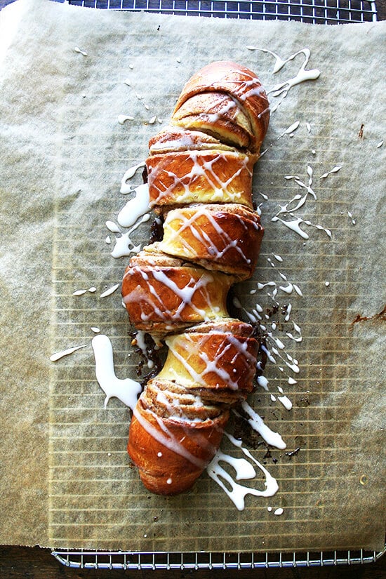 This is my favorite cinnamon pull-apart bread. The loaf stretches from corner to corner of the sheetpan and oozes with cinnamon and sugar upon baking. You'll tuck in immediately, pulling at the nearest coil, spreading cream cheese icing over each bite, eating and talking and sipping coffee until not a crumb remains. // alexandracooks.com Cinnamon pull-apart bread, freshly baked, drizzled with icing.
