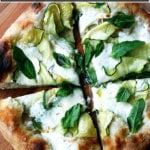A summer squash pizza cut into quarters.