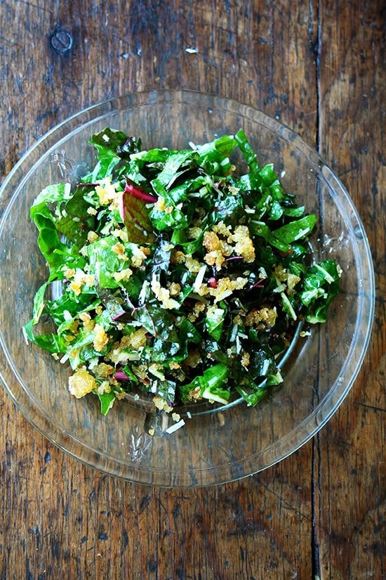 A plate of Swiss chard salad with bread crumbs, parmesan and a lemon dressing. 