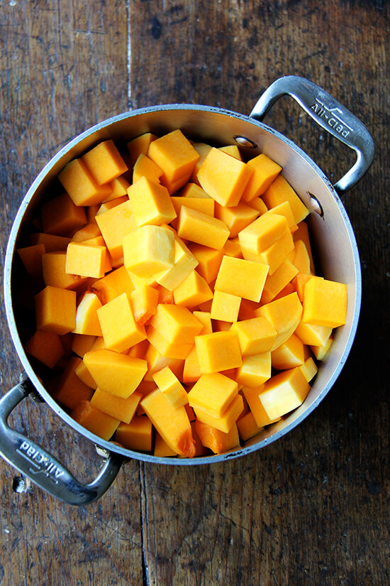 A soup pot with cubed butternut squash in it.