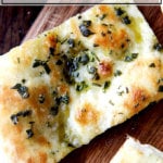 Herbed flatbread on a board.