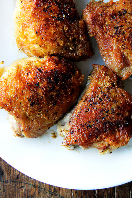 An overhead shot of crispy chicken thighs on a plate.