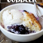 A bowl of blueberry cobbler with ice cream.