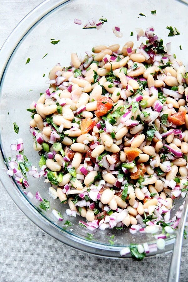 We've been eating this white bean and orange salsa, mixed with onions, lime, jalapeƱos, cilantro, and orange, with chips, but it would be nice tucked inside a taco or a burrito or aside spicy wings and nachos and anything else you might find yourself surrounded by on game day. // alexandracooks.com A large bowl of white bean and orange salsa.