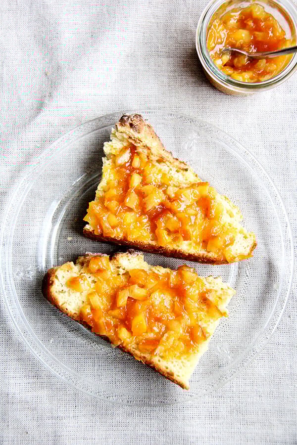 A plate of Irish soda bread slathered with orange marmalade. 