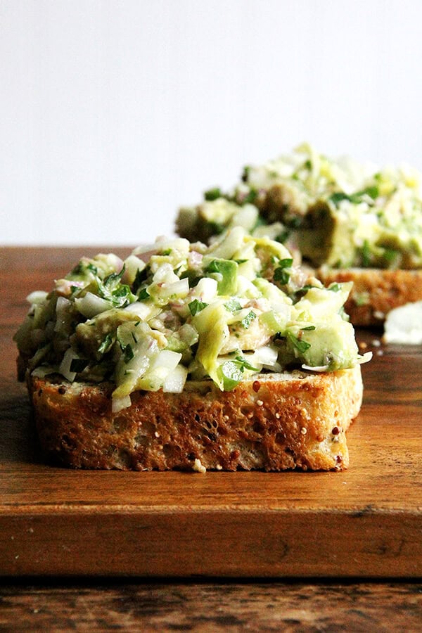 Two toasts topped with smoked trout and avocado salad.