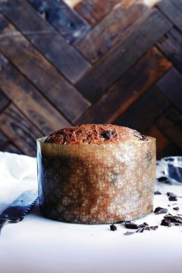 Baked chocolate-studded panettone bread recipe wrapped in large paper mould.