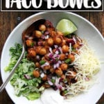Chickpea taco bowl with lettuce, sour cream, lime, and grated Cheddar.
