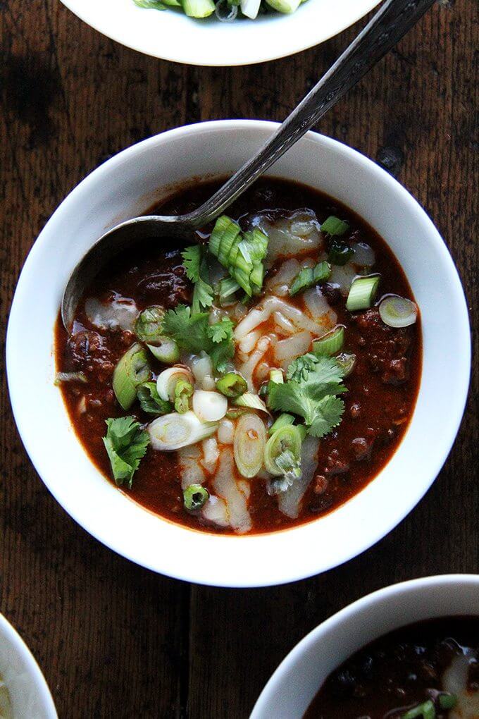 This super bowl menu includes weeknight chili which is my favorite, pared-down chili recipe. It comes together in about an hour and gets better by the day, so don't be afraid to make it ahead of time. // alexandracooks.com A bowl of weeknight chili topped with cheddar, scallions and cilantro.