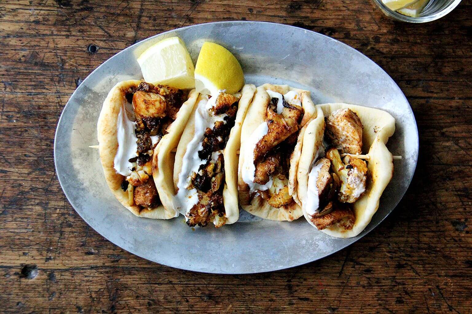 A sizzle pan of sheet pan chicken and cauliflower shawarma.