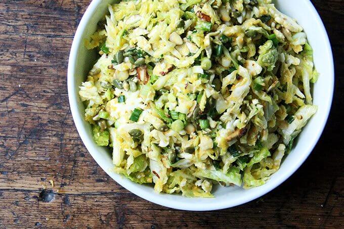 A white bowl filled with cabbage salad dressed in miso-carrot dressing.