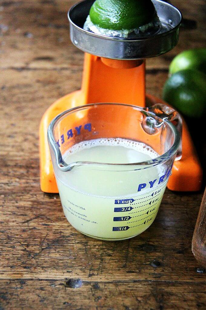 A cup of fresh-squeezed lime juice in a liquid measure.