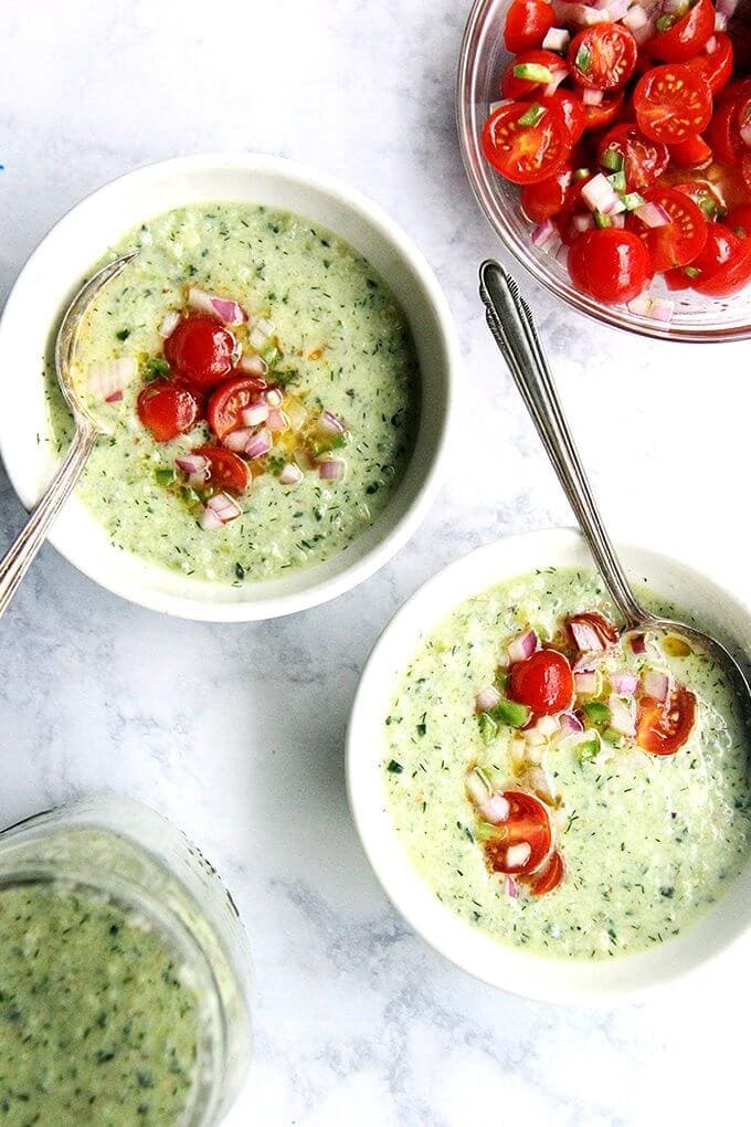 This cucumber and green grape gazpacho is one of my favorites: cucumber and green grape gazpacho, a variation of the chilled Spanish soup ajo blanco. It's loaded with dill and heavy on the vinegar, which gives it a nice bite. Sweet green grapes balance this sharpness, and a clove of minced garlic gives it a surprising zing. With the help of a food processor, it comes together in a snap // alexandracooks.com Two bowls of cucumber grape gazpacho with tomato salsa.