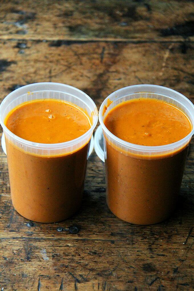 As delicious and simple as this tomato sauce is, I find the peeling step often deters me from making it. So I've stopped peeling the tomatoes and click here to find out what I do instead. Once you're finished making it, taste your fresh, bright tomato sauce, then smile for days as you put it on everything. // alexandracooks.com Two quart containers filled with tomato sauce.