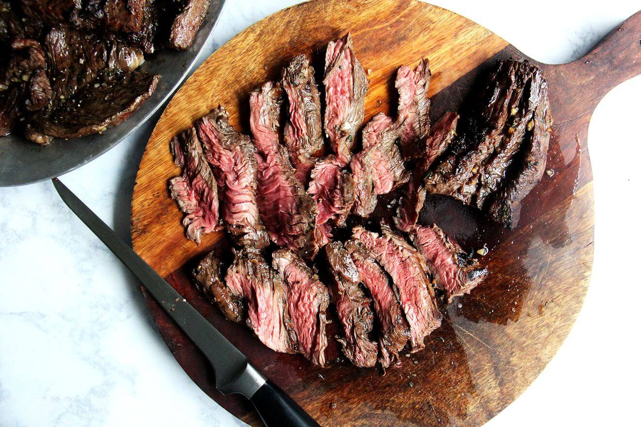 Sliced hanger steak on a cutting board.