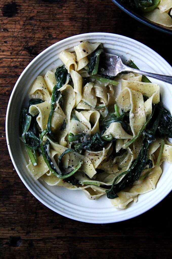 I love the addition of bacon found in classic carbonara recipes but it's not missed in this no-bacon pasta carbonara. And though the heap of greens wilts down to seemingly nothing, I know it's there, doing all the good things a heap of greens ought to be doing. // alexandracooks.com A plate of no-bacon carbonara loaded with greens.