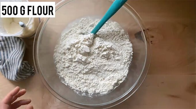 A bowl holding water, salt, flour, and sourdough starter.