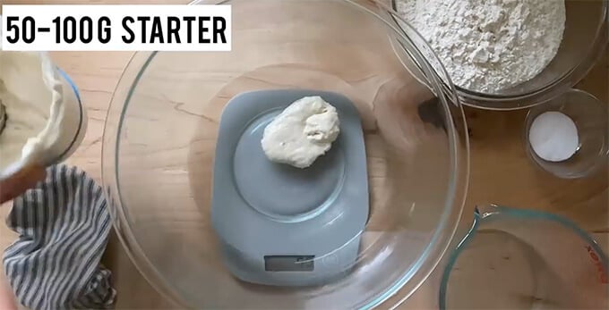 A bowl on a scale holding water and sourdough starter.