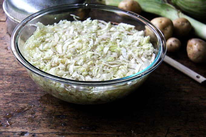 A large bowl filled with sliced cabbage covered in boiling water.