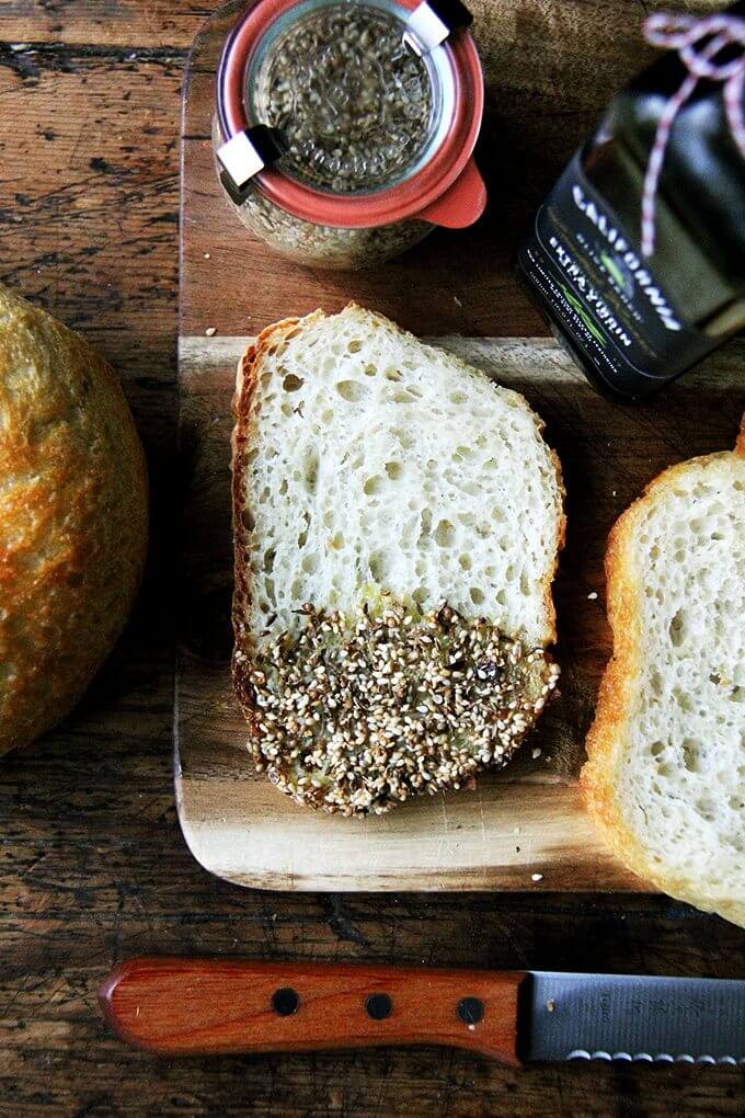 Fresh bread, good olive oil, a smoky, seedy dukkah—this appetizer reminded me how a simple flourish can make such an impression—it can be, in fact, all everyone needs to kick off an evening; it can be everything everyone dreams about for days. // alexandracooks.com A board with sliced bread dipped in olive oil and dukkah.