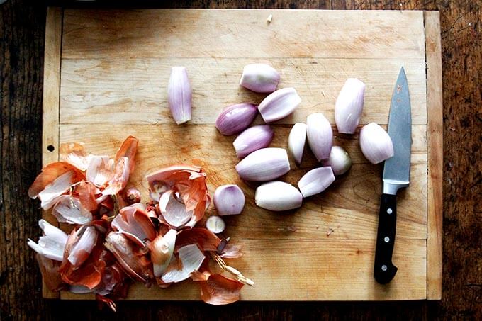 A board with peeled shallots. 