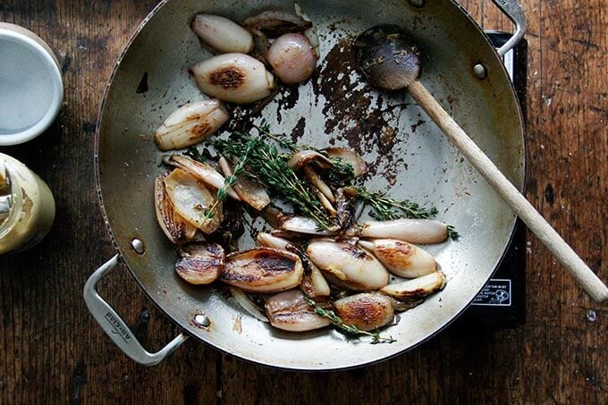 A skillet with browned shallots. 