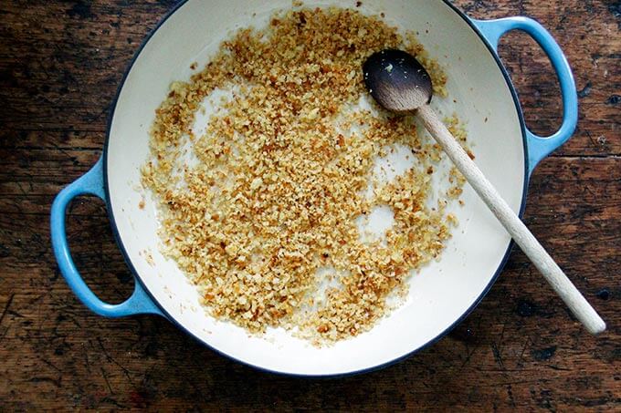 Overhead shot of a large skillet filled with toasted bread crumbs. 