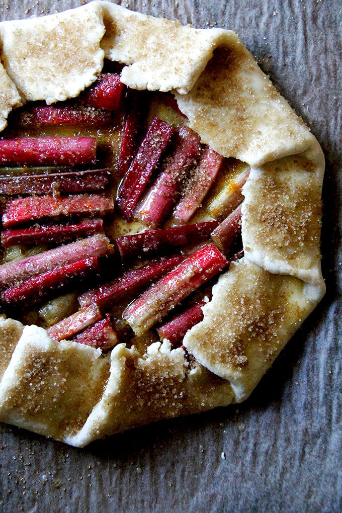 Galette on a sheet pan, brushed with egg wash, sprinkled with sugar, ready to be baked.