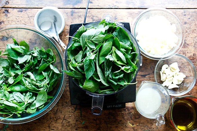 A food processor filled with pesto ingredients.