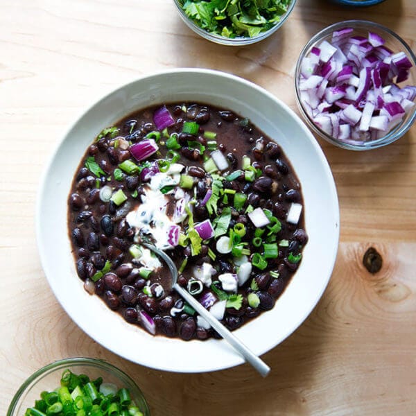 A bowl of Cal Peternell's black bean soup with garnishes.