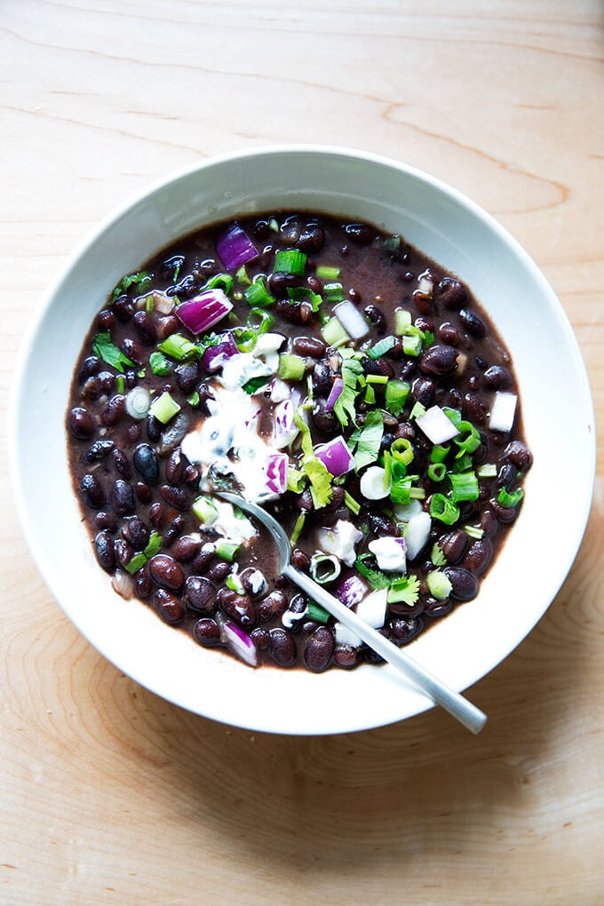 A bowl of black bean soup with all of the garnishes.