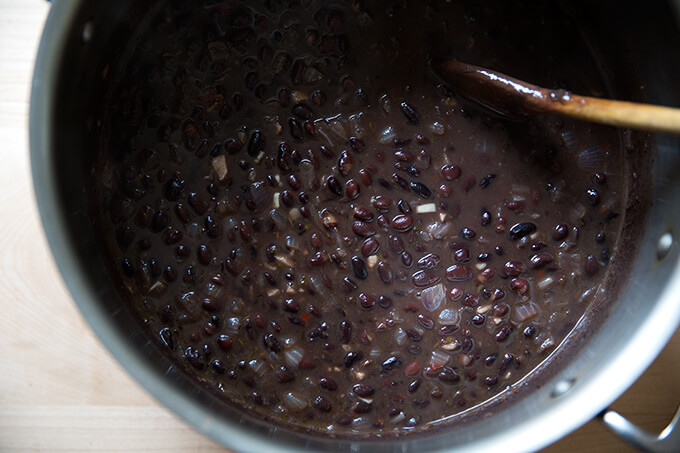 A pot with cooked black bean soup.