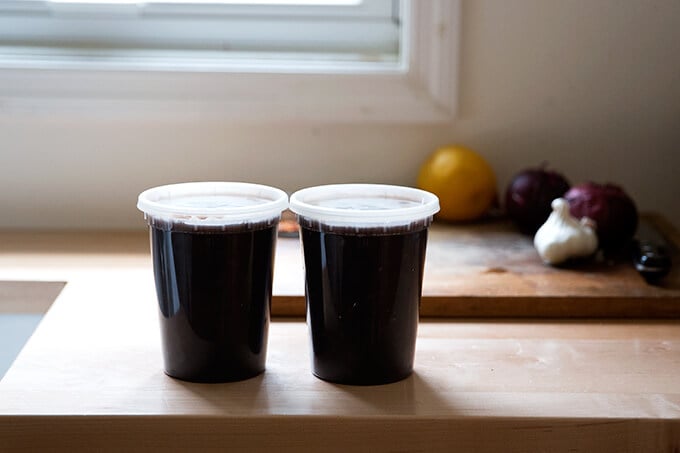 Two quart containers holding cooked black beans.