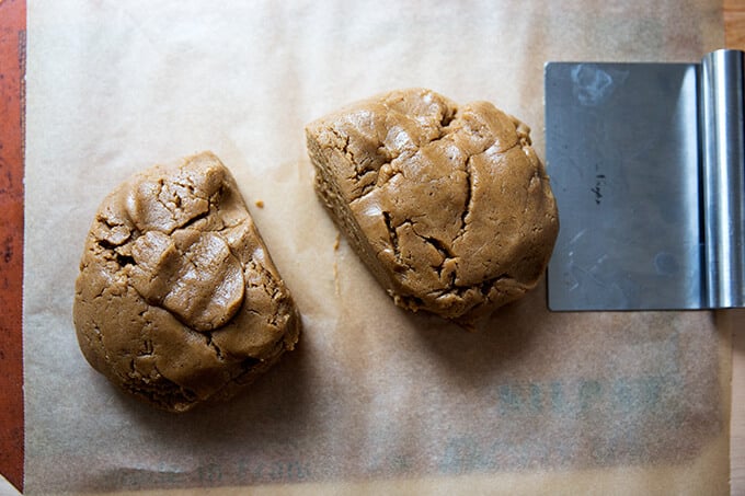 mixed dough divided in two portions on a silpat lined cookie sheet with a bench scraper.