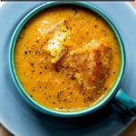 A bowl of carrot-ginger soup in a mug.