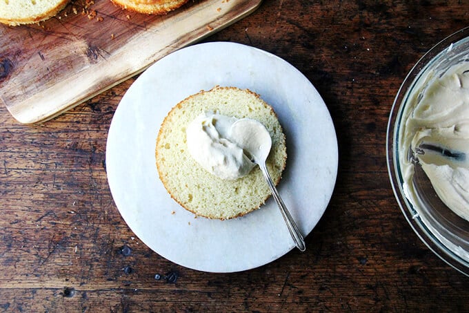 One-Bowl Buttermilk Birthday Cake being assembled on a cake platter. 