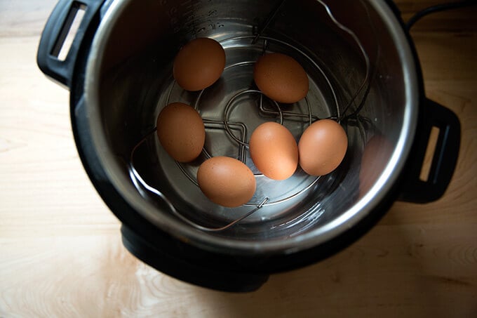 The Instant Pot 6-qt IP Duo with 6 uncooked eggs and water in the inner pot.