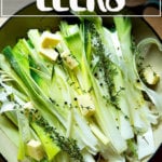 A skillet holding un-braised leeks.